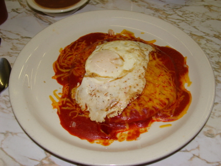 Red enchiladas with an egg on top