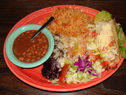 Combination plate with mole enchilada, red enchilada, chile relleno, and chicken taco