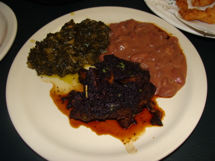 Blackened pork chop, collard greens, and red beans